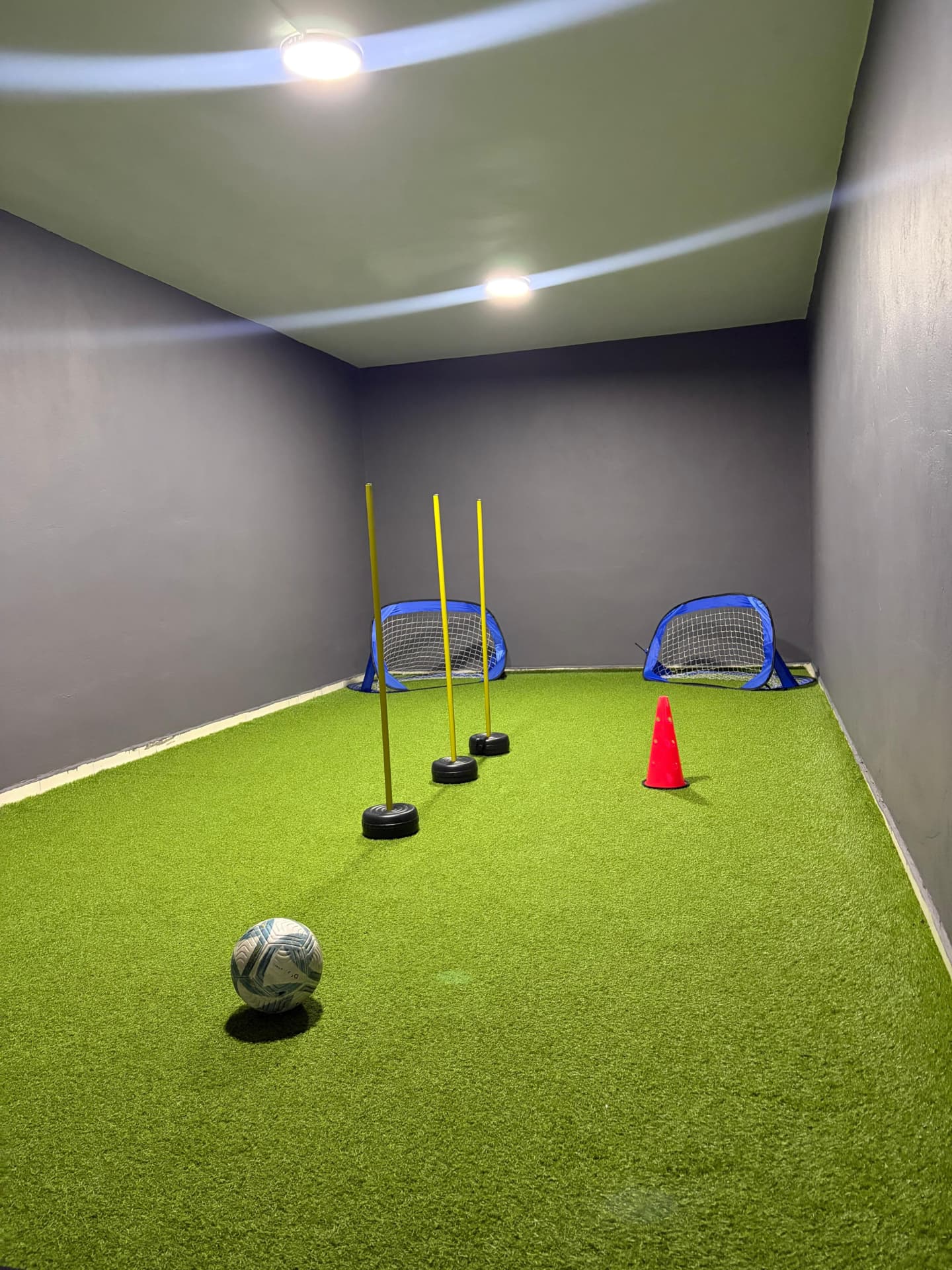 Slalom çubukları, huni ve futbol topu ile teknik çalışma alanı
